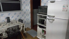 A compact kitchen with a refrigerator, microwave, and a small oven. - 3 bedroom apartment nearby. Puc Cor Eucar Gameleira Expom Aren Galo MRV Cid Ind BR040 262 (Belo Horizonte)