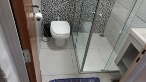 A small bathroom with a toilet, a glass shower enclosure, and a white sink. - 3 bedroom apartment nearby. Puc Cor Eucar Gameleira Expom Aren Galo MRV Cid Ind BR040 262 (Belo Horizonte)