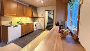 A modern kitchen with wooden cabinets, a built-in oven, and a countertop with a fruit bowl. - Riverside Villa with a Private Jetty and Scenic Views (Torpshammar)