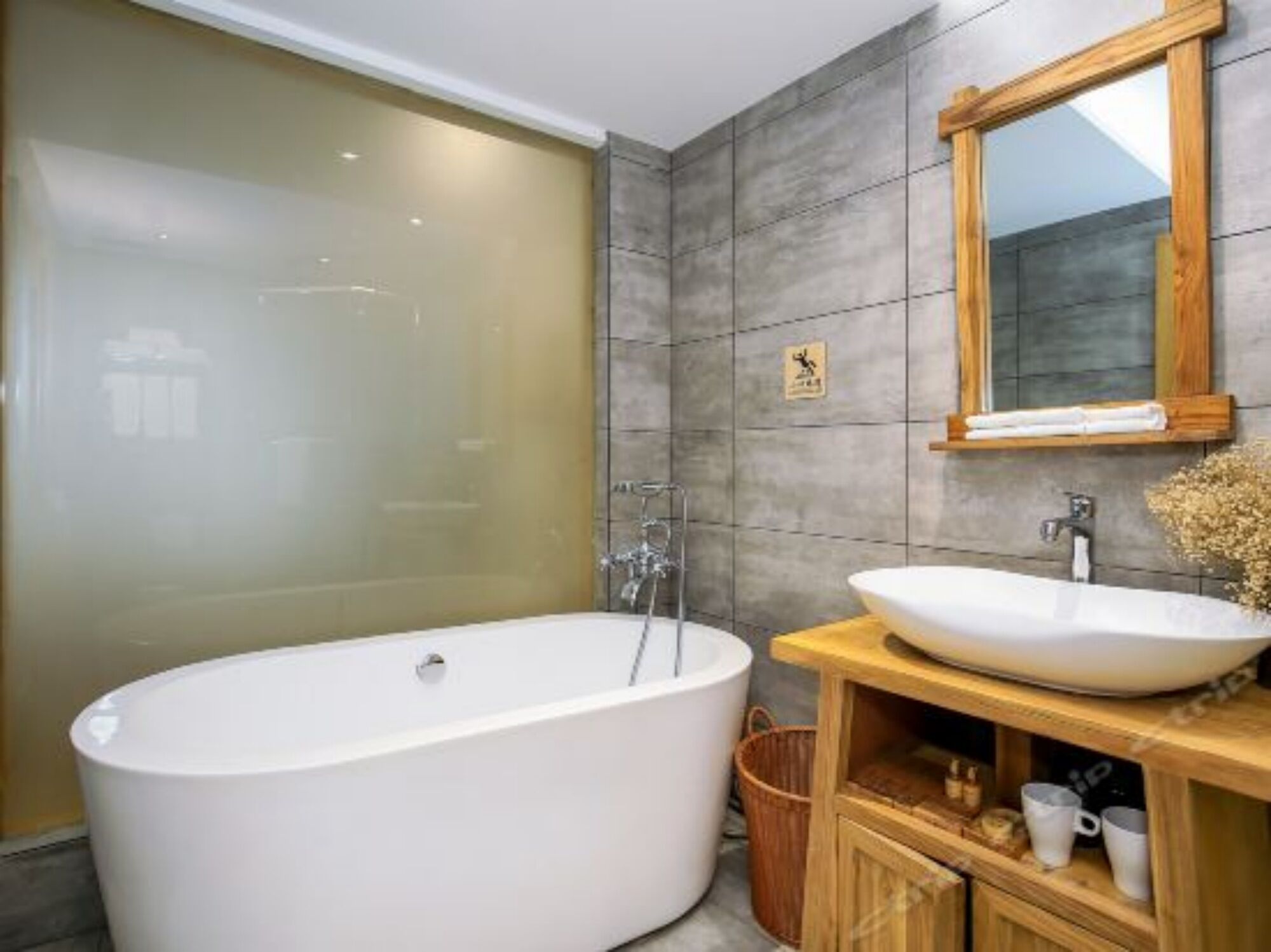 Une salle de bain moderne avec une baignoire sur pieds, un meuble-lavabo en bois doté d’un grand évier et un miroir au-dessus du meuble-lavabo.