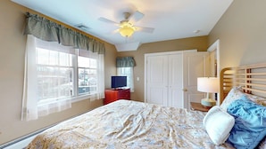 A bedroom with a bed, a television, a desk, a lamp, and a ceiling fan. - 2-bedroom Apartment in Beautiful Stonington Boro (Stonington)