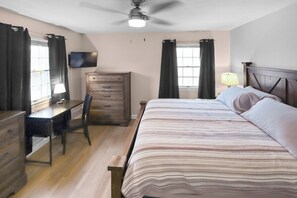 A bedroom with a bed, desk, chair, dresser, and a ceiling fan. - Modern 3BR West Omaha, Private Pool now open, Fenced Yard, W/D, Pet-Friendly (Omaha)