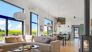 Een moderne woonkamer met een bank, salontafel en een eethoek.