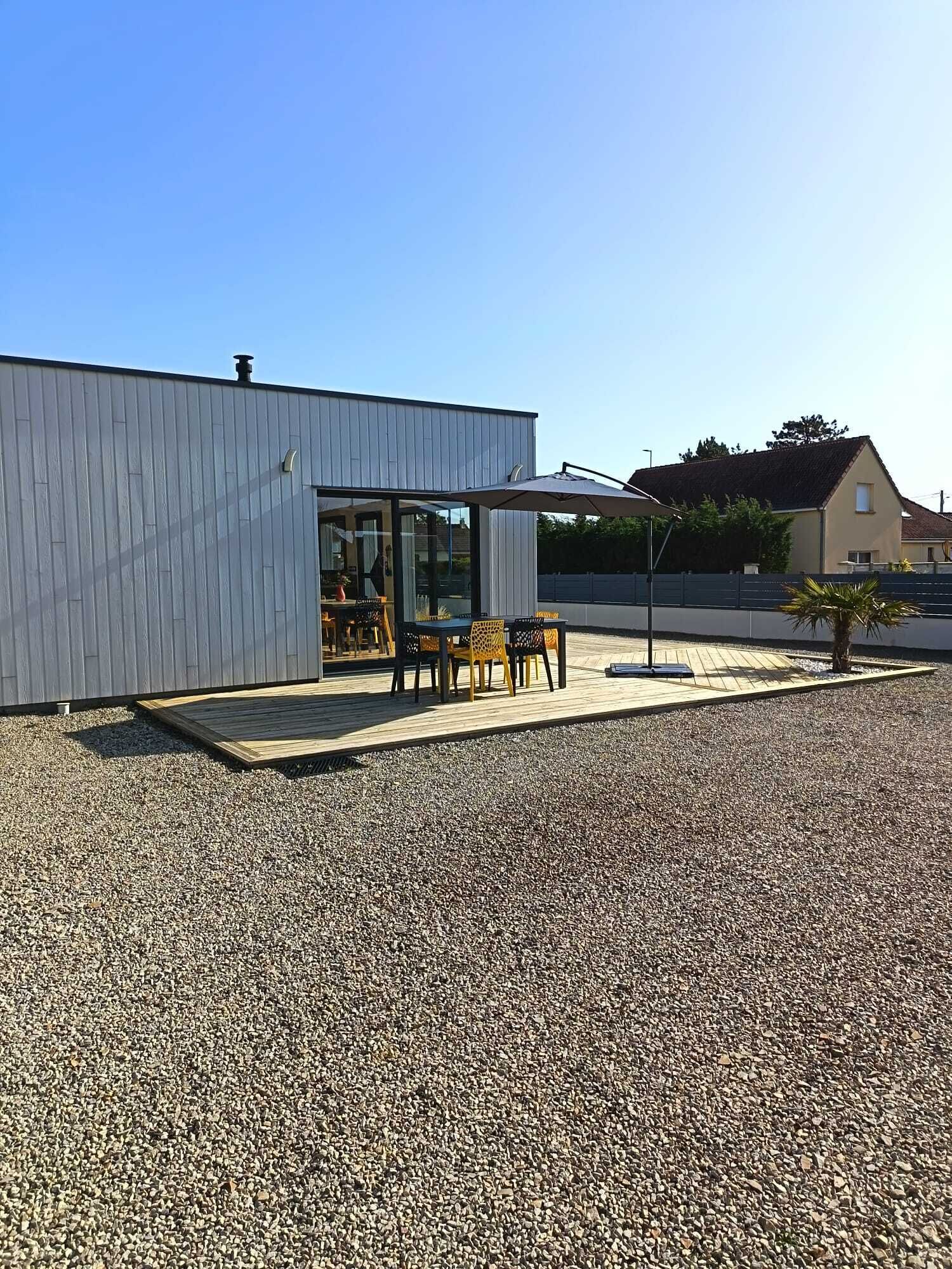 A modern building with a covered patio area featuring outdoor seating.