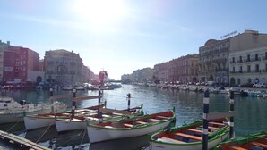 Un port de plaisance où sont amarrés des bateaux, entouré de bâtiments historiques.