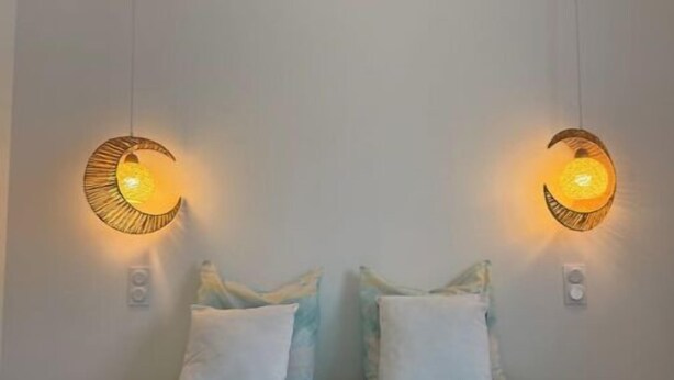 A hotel room with a bed, two wall-mounted lamps, and towels on the bed. - Family home with spa bath in one of the most beautiful villages in France ! (Rochefort-en-Terre)