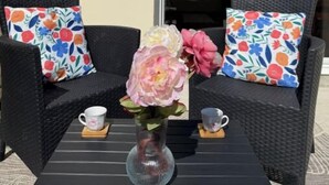 A patio area with wicker furniture and a table. - Family home with spa bath in one of the most beautiful villages in France ! (Rochefort-en-Terre)
