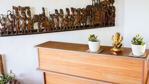 Una scrivania in legno con due piante in vaso e un elemento decorativo a parete.