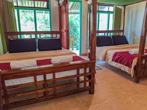 A room with two wooden beds, each with a headboard and footboard, and a window with curtains. - Velora Hill Ella (Ella)
