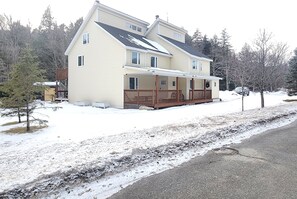 A two-story house with a porch and a covered entryway. - Valley Trail Riverfront Townhouse with EV Charging 2 miles from Mount Snow (Dover)