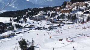 A ski resort with multiple buildings, a ski slope, and a mountain backdrop. - Renovated studio cabin near slopes, 4 pers. (Bolquère-Pyrénées 2000)