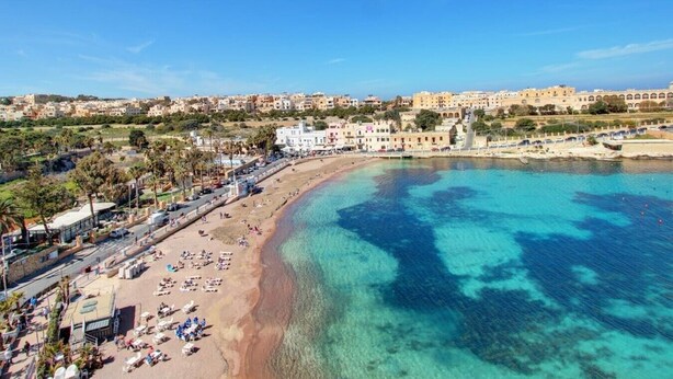 A coastal town with a beach, clear blue waters, and buildings along the shore. - Ortigia Collection / Suite No.1 / Terrace (Swieqi)