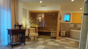 Um quarto com chão xadrez, um armário de madeira, uma máquina de costura, uma cadeira e uma pequena mesa.