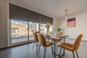 Ein Essbereich mit großem Fenster, einem Tisch für vier Personen und einer Blumenvase.