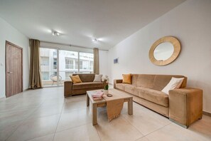 Ein modernes Wohnzimmer mit zwei Sofas, einem Couchtisch und einem großen Fenster.