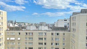 Un immeuble à étages doté d’une façade sobre, de nombreuses fenêtres et surplombant un ciel dégagé parsemé de quelques nuages.