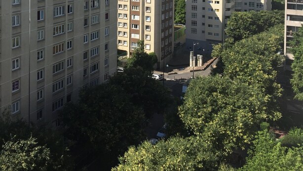 Un immeuble résidentiel de grande hauteur, doté de nombreux étages, de grandes fenêtres et d’un toit plat.