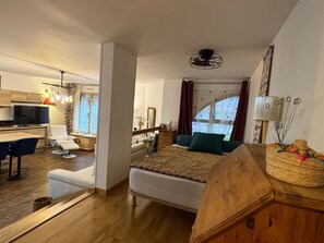Ein gemütliches Schlafzimmer mit Bett, Nachttisch und Blick auf den Wohnbereich.