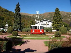 A red and white tram in a park with a building in the background. - Cozy apartment with terrace and WIFI in Saint-Lary (Saint-Lary-Soulan)