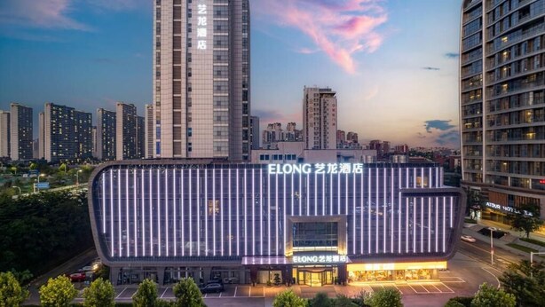 Un hotel moderno con fachada curva y señalización iluminada.