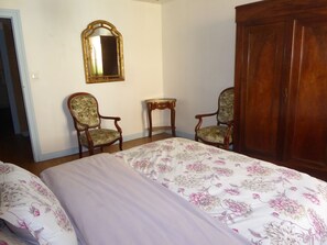 A room with two beds, a wooden wardrobe, a mirror, and two chairs. - Maison Marius—pets allowed—1,600 m² fenced-in garden—heated pool (Le Buisson-de-Cadouin)