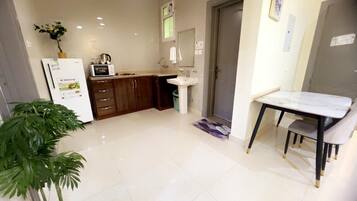 A modern kitchen with a refrigerator, microwave, sink, and wooden cabinets.
