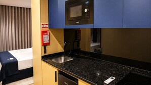 Una cocina compacta con microondas, pileta y lavavajillas.