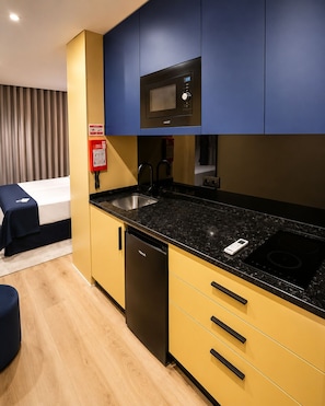A compact kitchen with a microwave, sink, and dishwasher.