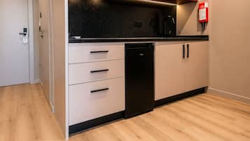 Une cuisine moderne équipée d’un four à micro-ondes, d’un lave-vaisselle et dotée d’un plancher en bois.
