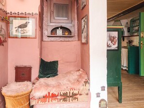 A room with a bed, a small chest, a green pillow, a woven basket, and a wall with framed pictures. - 6 Person Holiday Home in Glesborg (Glesborg)