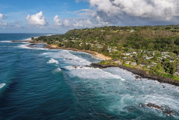 A coastal town with a beach, ocean waves, and residential buildings. - "Waimea Vista" | Oceanfront, Walkable to Beaches (Haleiwa)