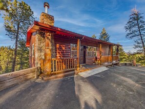 A rustic cabin with a stone chimney, wooden logs, and a metal roof. - Salty Pines - Scenic Log Cabin w/ Hot Tub, Sierra Blanca Views & Pet-Friendly (Ruidoso)