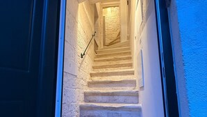 Un escalier menant à un palier, avec une rampe et un paillasson au bas.