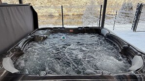 A hot tub with a view of a snowy landscape through a window. - Chez Maud et Fab (Dinozé)