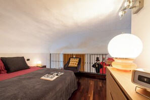 A bedroom with a bed, a nightstand, a lamp, and a mirror. - Le Vintage - Stylish Lofts in the Historic Center (Torino)