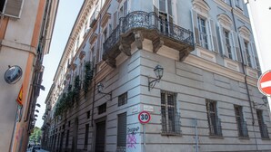 Eine enge Straße mit historischen Gebäuden, einem Kopfsteinpflasterweg und einem Geschwindigkeitsbegrenzungsschild.