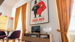 Ein modernes Wohnzimmer mit einem Holzkasten, einem Fernseher und einem gerahmten Poster an der Wand.
