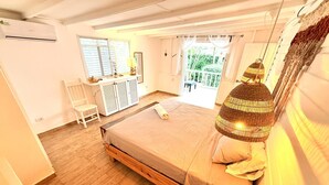 Een slaapkamer met een houten bed, een bureau, een stoel en een raam met gordijnen.