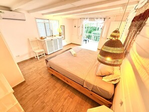 A bedroom with a wooden bed, a desk, a chair, and a window with curtains. - A little piece of paradise, LAS TERRENAS, 2 bedrooms, 2 bathrooms, pool, parking, completely private. (Las Terrenas)