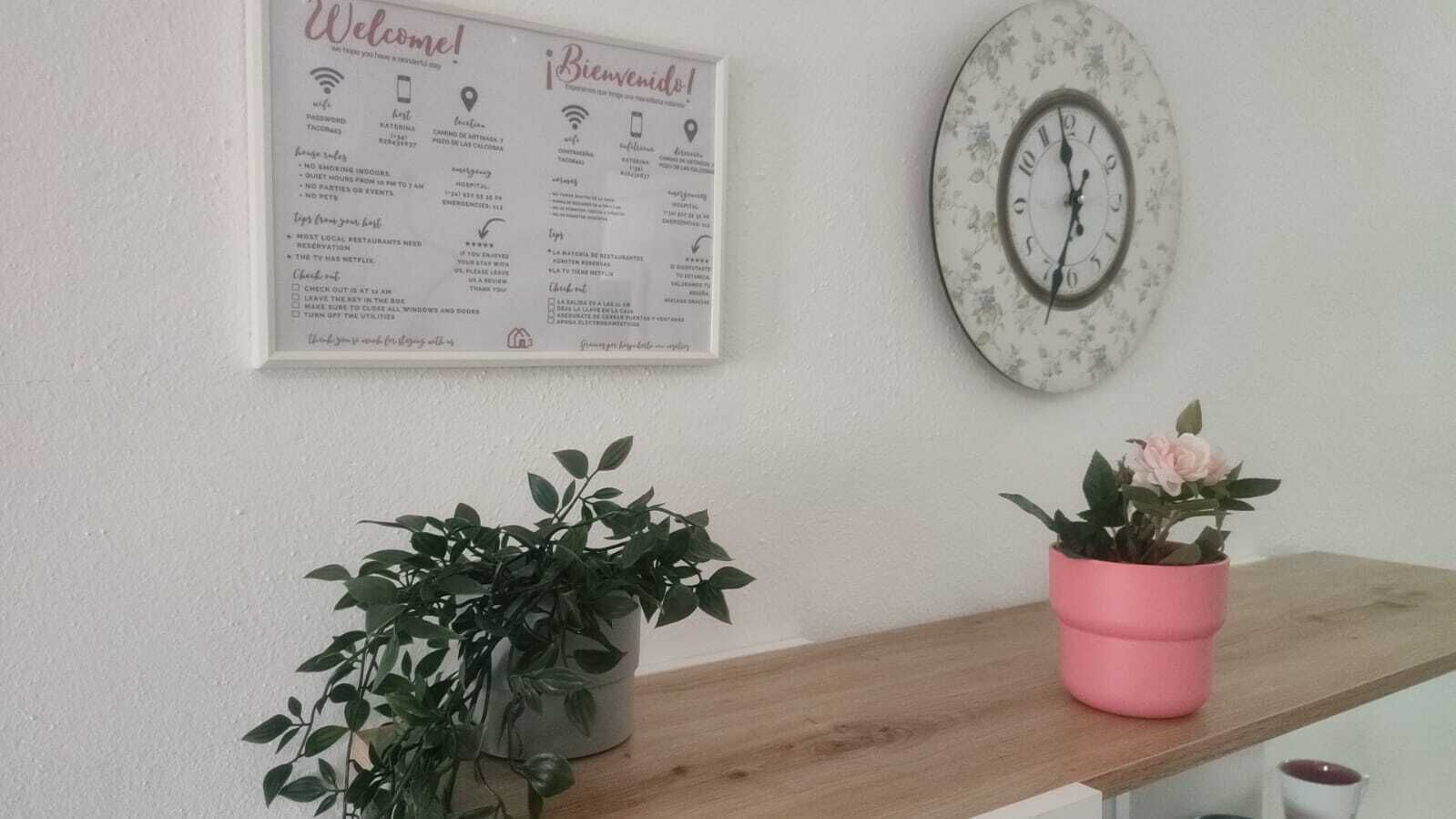 Un panneau d’accueil indiquant les commodités disponibles et une horloge fixée au mur.