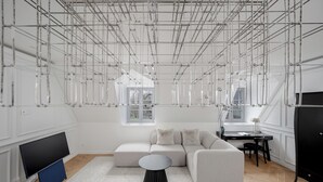 A modern living room with a sectional sofa, a round coffee table, a flat-screen TV, and a dining area with a table and chairs. - Luxury apartment in Old Town + Parking heart of Vilnius (Vilnius)