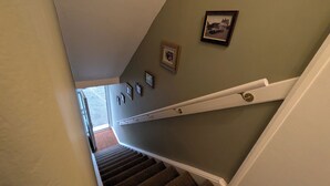 A staircase with carpeted steps, a handrail, and a wall with framed pictures. - digby house flat 1 (West Mersea)