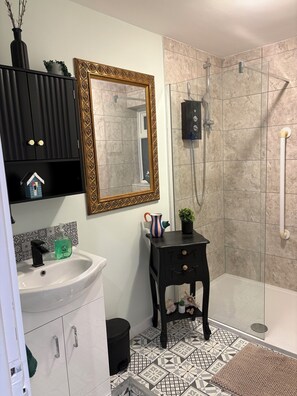 Regadera, secadora de cabello, toallas, papel de baño 