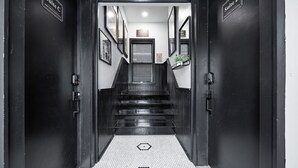 A black and white view of a hotel entrance with a staircase leading to a reception area. - German Village Studio: Charming & Pet-Friendly (Columbus)