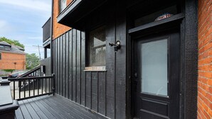 A black metal exterior with a glass door and a small window. - German Village Studio: Charming & Pet-Friendly (Columbus)