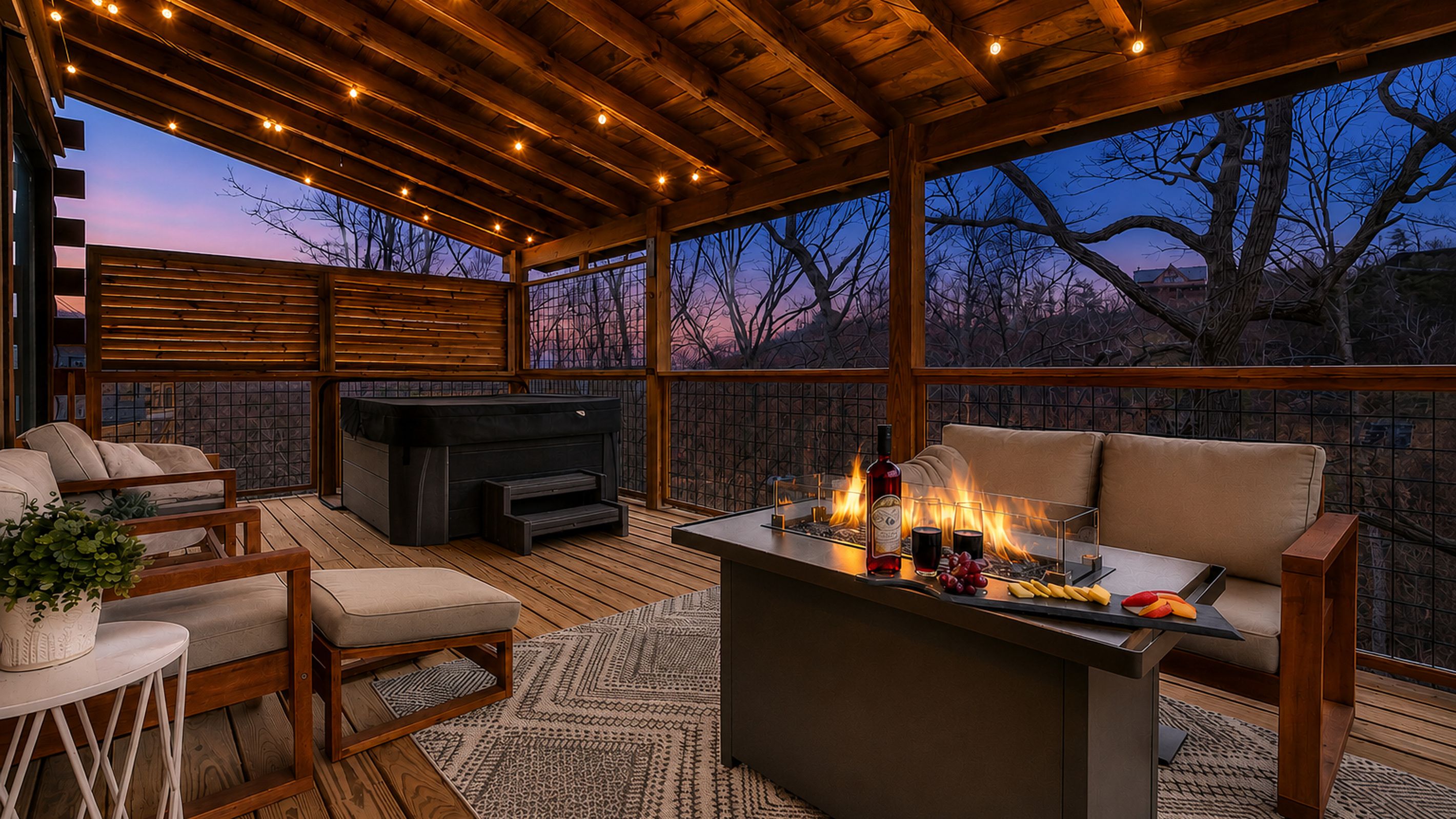 An outdoor deck with a fireplace, seating, and a view of the trees.