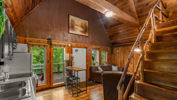 Ein rustikales Cabin-Interieur mit Küche, Essbereich und einer Treppe.