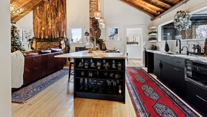 A spacious living area with a fireplace, a cozy seating area, and a kitchen with modern appliances. - Cozy river front 3 bedroom Colorado cabin (Colorado Springs)