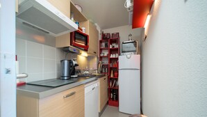 Eine kleine Küche mit Mikrowelle, Toaster und Kühlschrank.