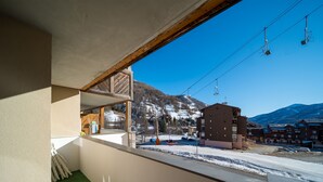 Ein Zimmer mit Blick auf einen verschneiten Berg und eine Seilbahn.